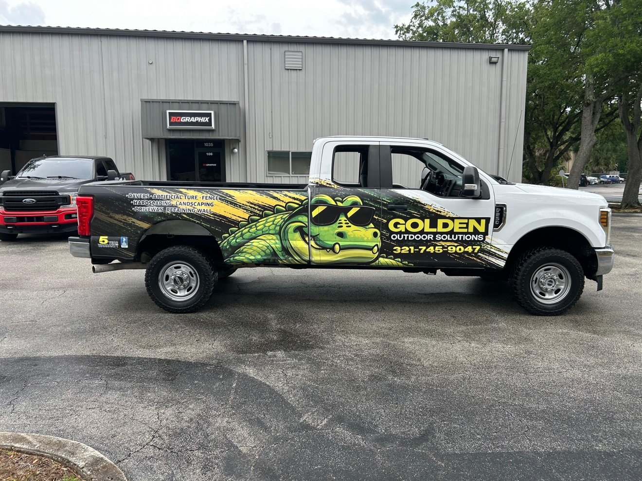 Ford pickup with a full Golden Outdoor Solutions gator wrap parked in front of the BQ Graphix shop