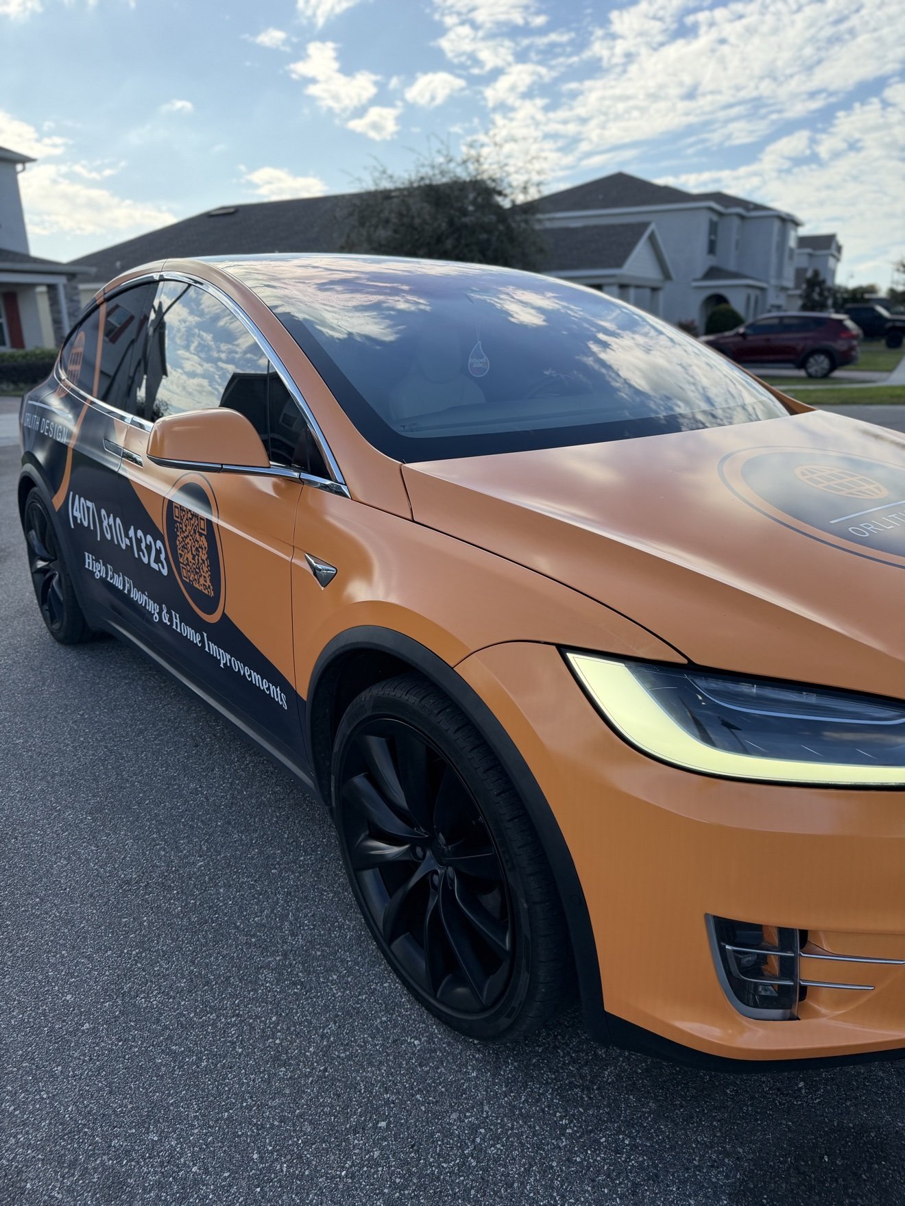 Tesla Model X with a commercial wrap for ORLITH, front three-quarter view
