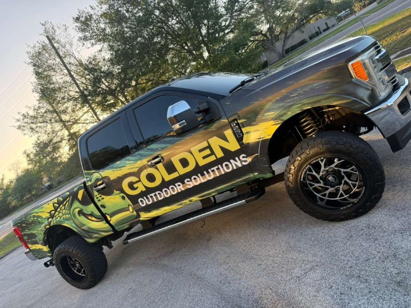 Lifted Ford F-250 with a Golden Outdoor Solutions gator wrap, side view