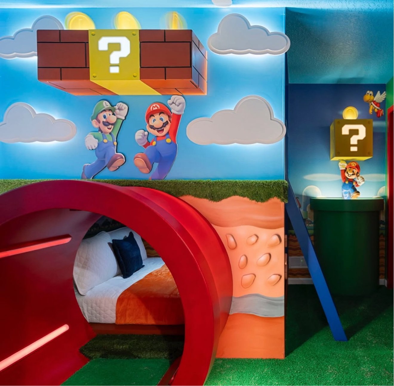 Super Mario themed room with a red slide tunnel bed, Mario and Luigi wall art and a glowing question block