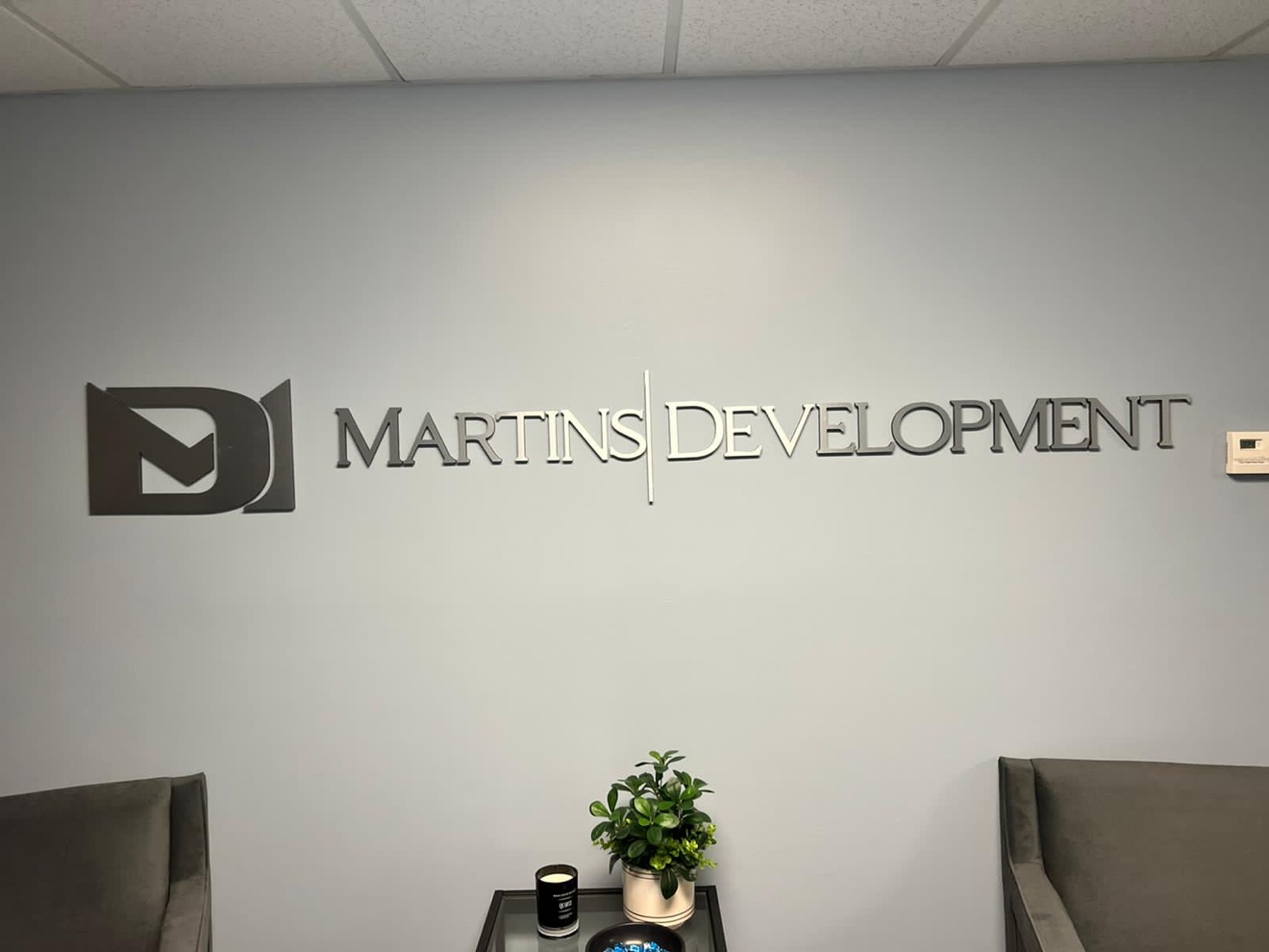 Martins Development logo and wall letters in brushed metal in an office lobby