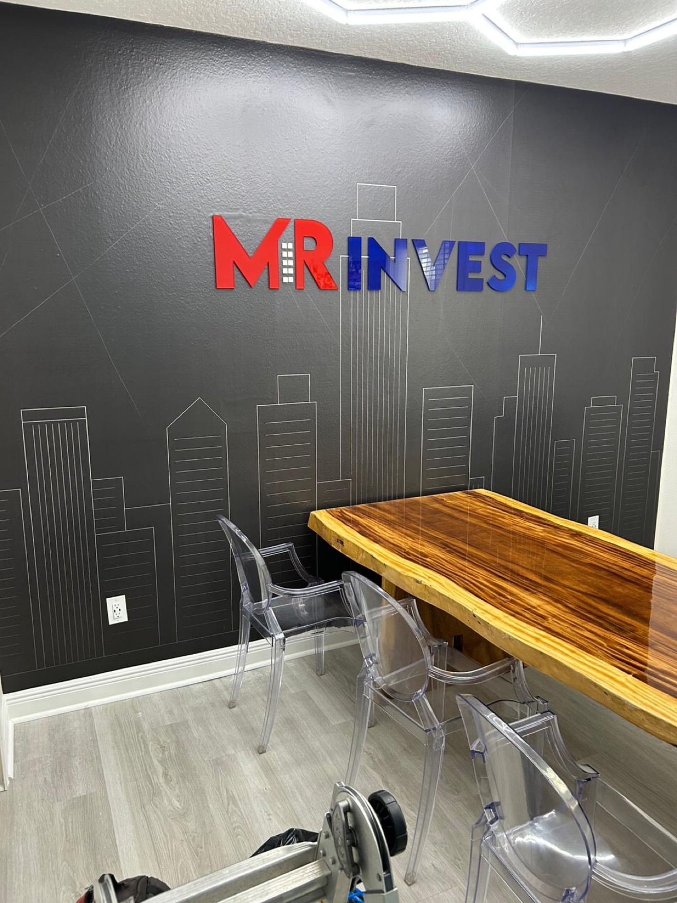 MR Invest dimensional letters over a city skyline wall wrap in a meeting room