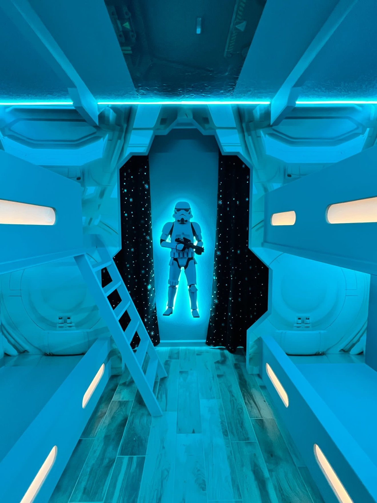 Stormtrooper cutout glowing blue with LED backlight in a spaceship-themed bunk room