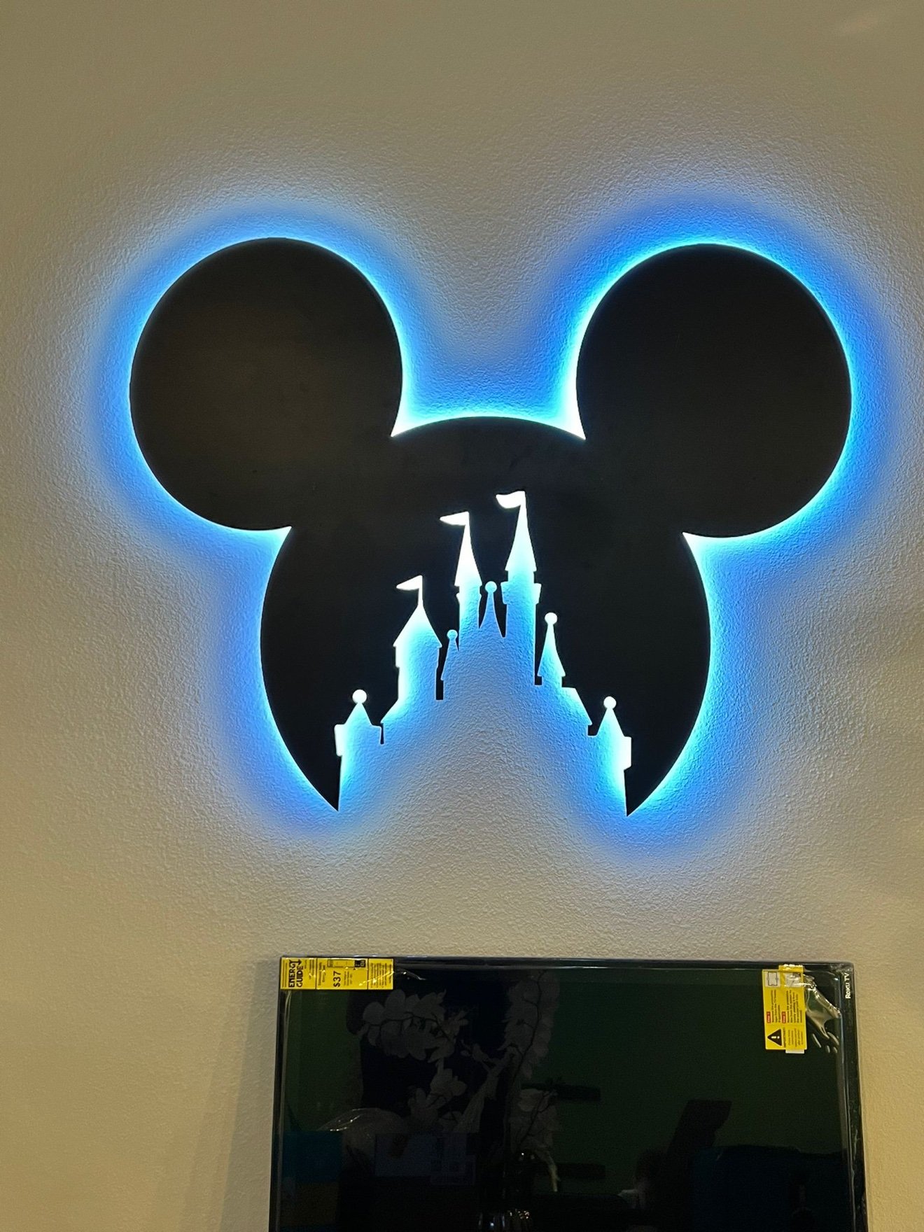 Mickey head cutout with a castle silhouette cut through it and blue LED backlight