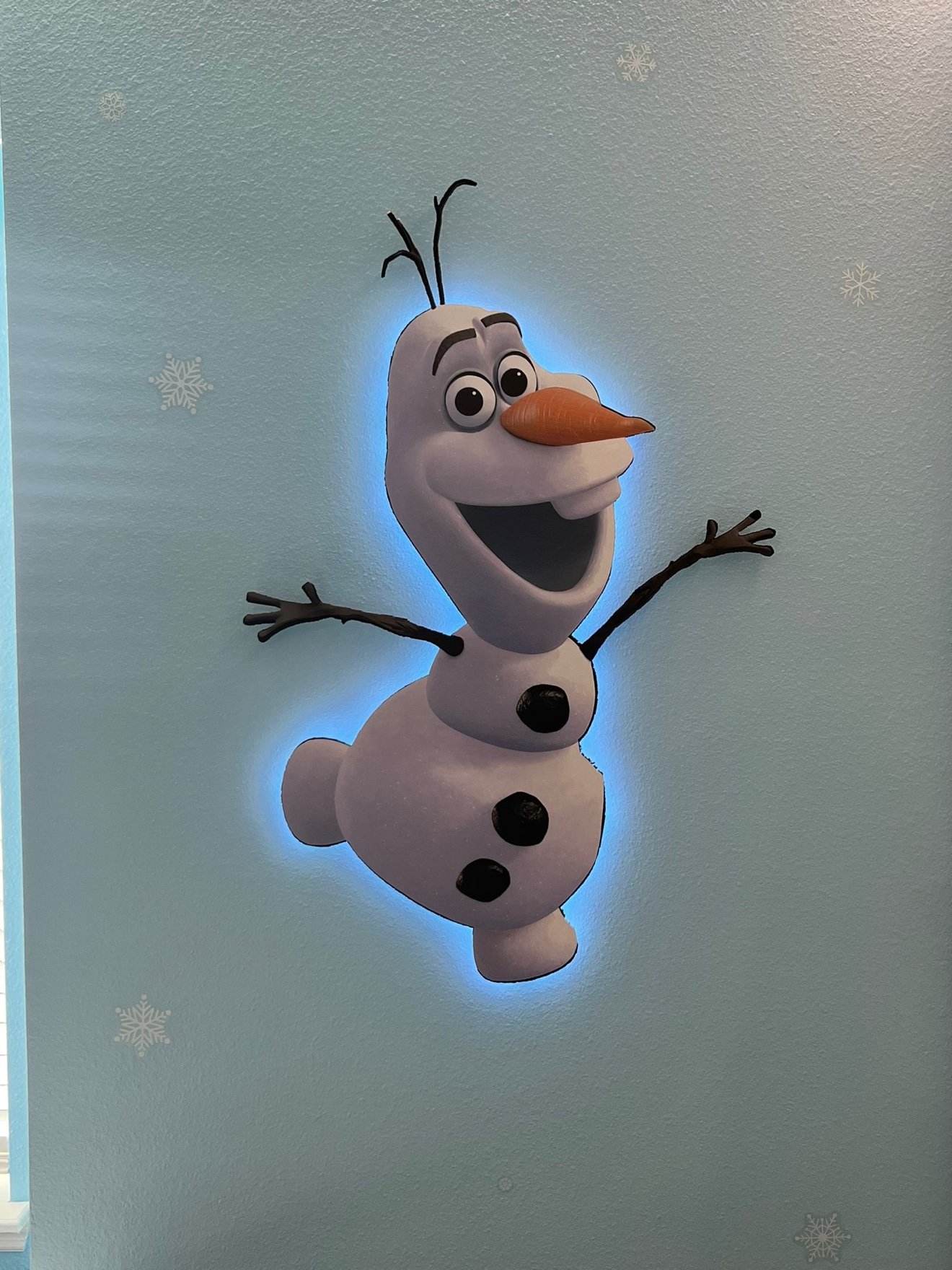 Olaf 3D cutout with a blue LED halo mounted on a light-blue wall